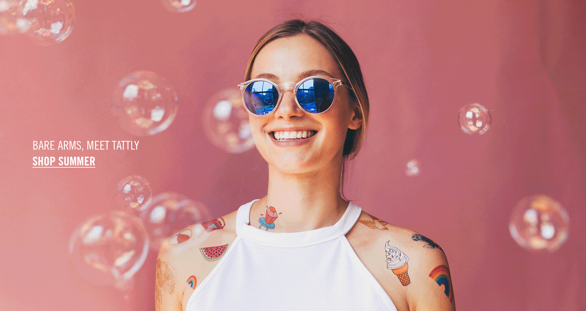 Mujer con lentes de sol sonriendo, posando sus tatuajes